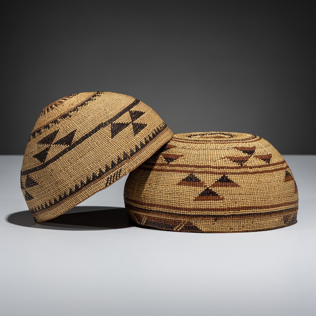 Northern California Basketry Caps: Northern California Basketry Caps first half 20th century lot of 2, each having bands of triangular decorations height 4 inches x diameter 6-1/2 inches AND height 3-3/4 inches x diameter 7 inches