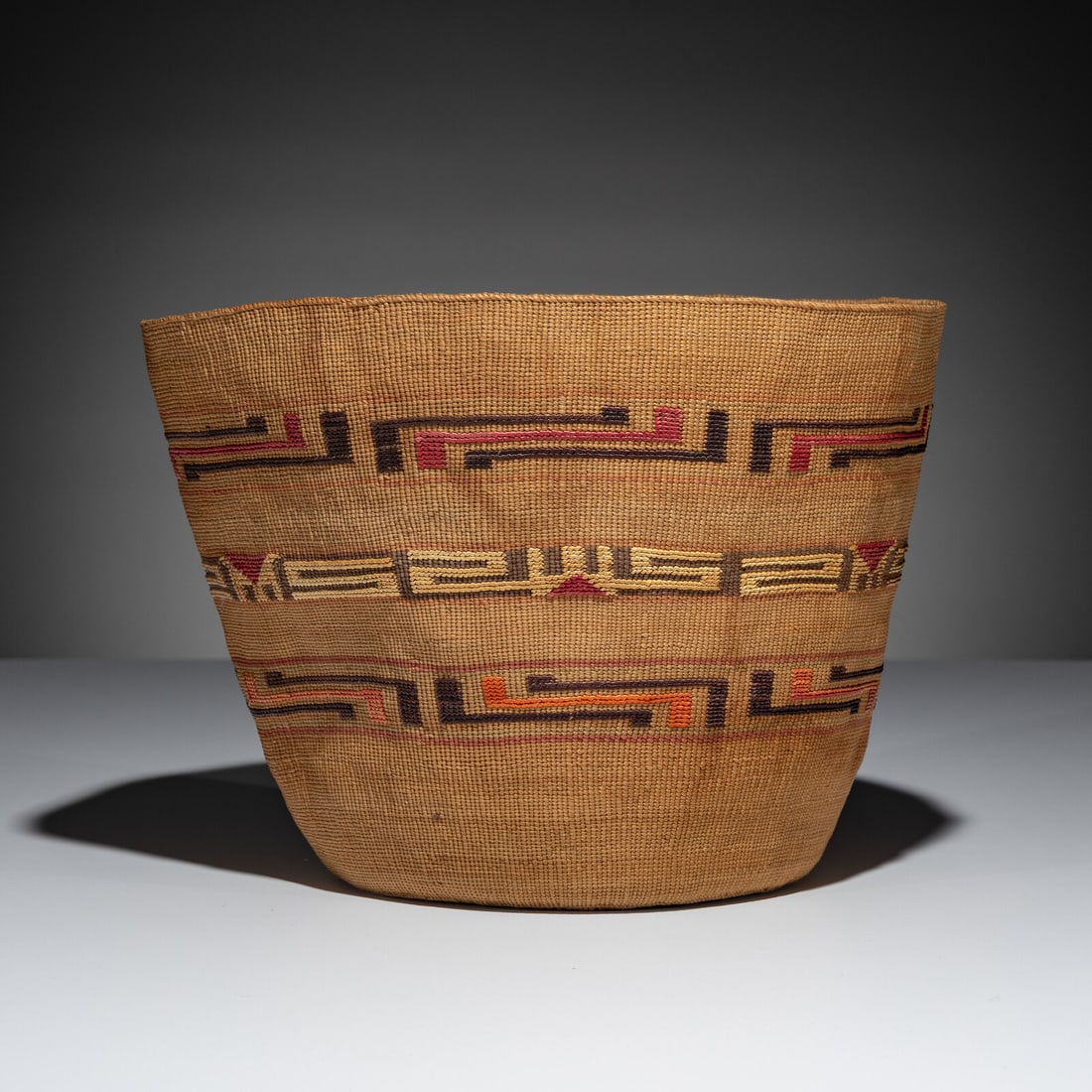 Tlingit Polychrome Berry Basket: Tlingit Polychrome Berry Basket late 19th century having three bands of false embroidery in bright colors of brown, red, cream, and orange height 8-1/4 inches x diameter 10 inches This lot is