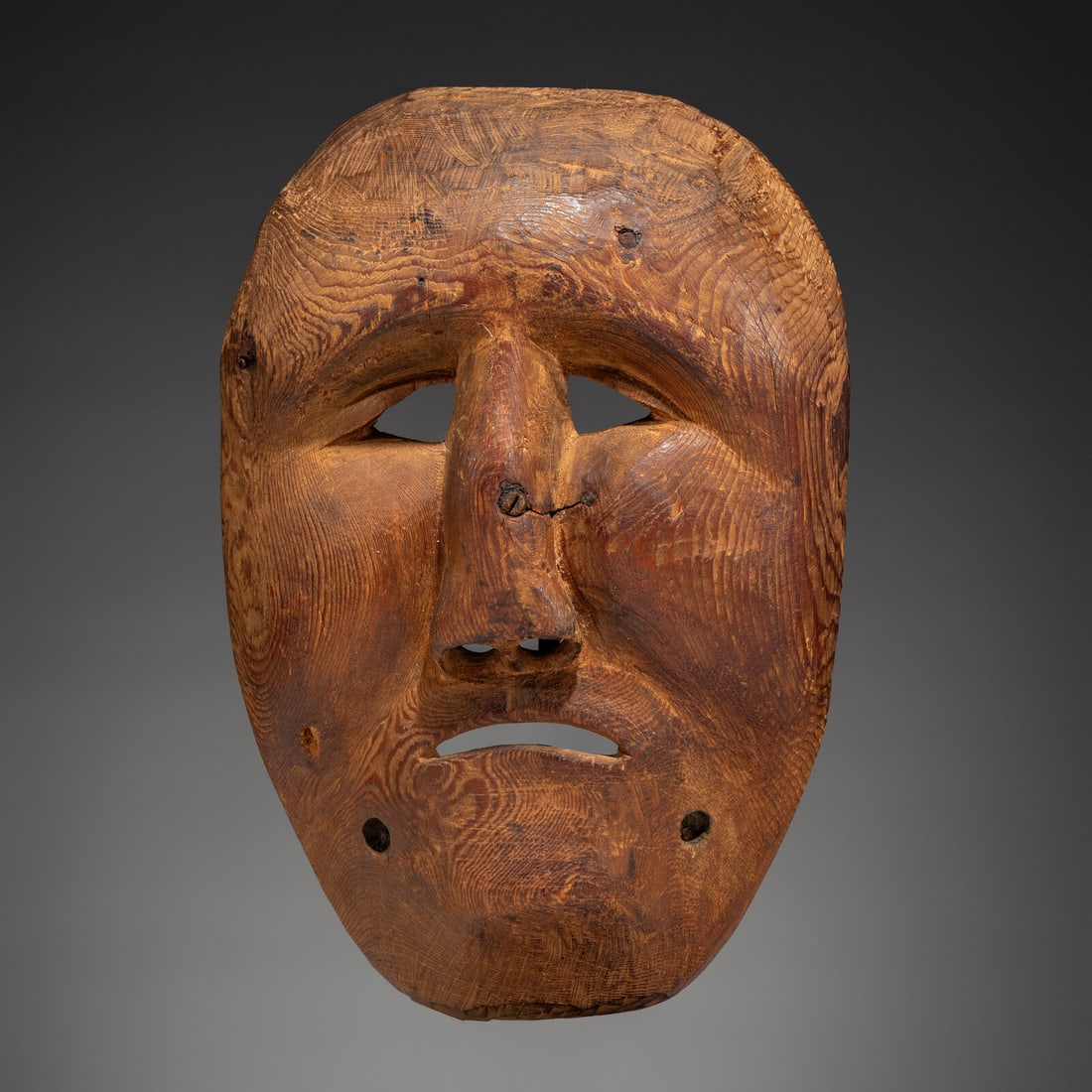 Point Hope Dance Mask: Point Hope Dance Mask ca 1900 female mask sculpturally carved with sad eyes and countenance; insets for labrets; remnants of old paper label on reverse length 10-1/4 inches x width 7 inches Ex
