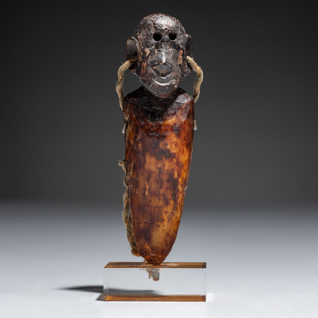 Saint Lawrence Island Punuk Period Figure: Saint Lawrence Island Punuk Period Figure pre-1200 carved of fossilized walrus, in human form; pierced through for attachment length 3-1/2 inches Ex Jeffery Myers Collection This lot is located in