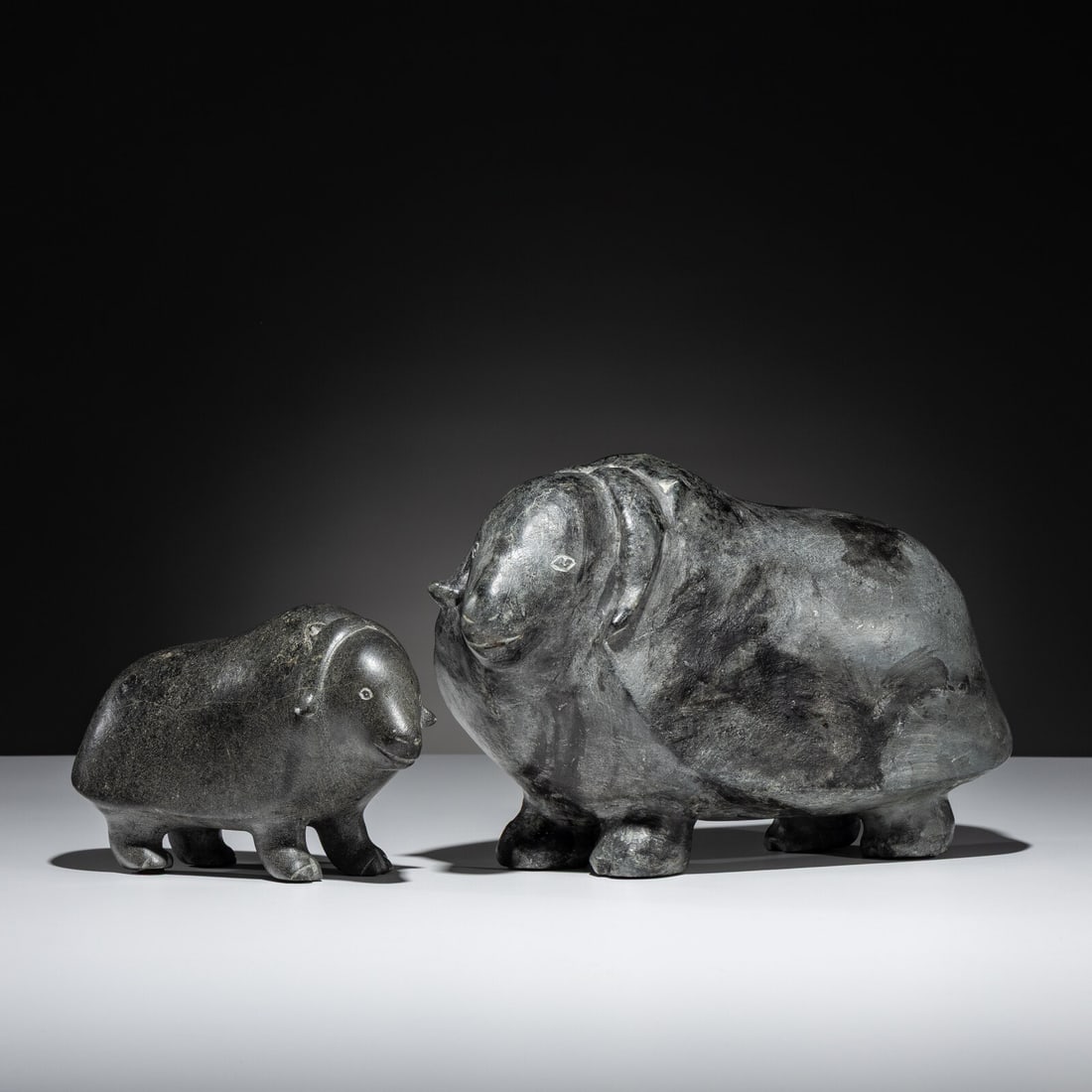 Mathew Aqigaaq (Inuit [Qamani'tuaq], 1940-2010) Muskoxen: Mathew Aqigaaq (Inuit [Qamani'tuaq], 1940-2010) Muskoxen lot of 2, each signed in syllabics height 5-1/4 inches x length 7-3/4 inches x width 3-1/2 inches AND height 8 inches x length 12 inches x