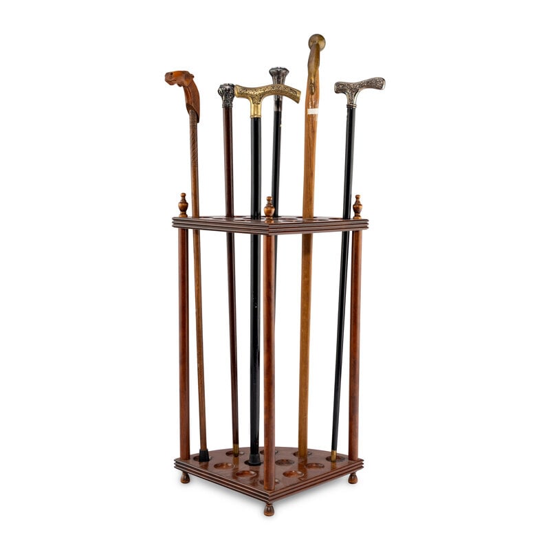 A Collection of Six Gentleman's Walking Sticks with Stand: A Collection of Six Gentleman's Walking Sticks with Stand includes two patinated brass handle canes, a carved horse cane, a silver plate handle cane and two Italian clock handle canes.Stand