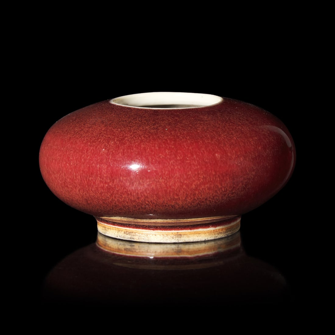 A Chinese Copper Red Glazed Water Coupe, Qing Dynasty 清 寶石紅釉: A Chinese Copper Red Glazed Water Coupe, Qing Dynasty 清 寶石紅釉堂鑼洗 Of vibrant red tone, the coupe rising from a tall foot. Diameter 4 in., 10.2 cm.