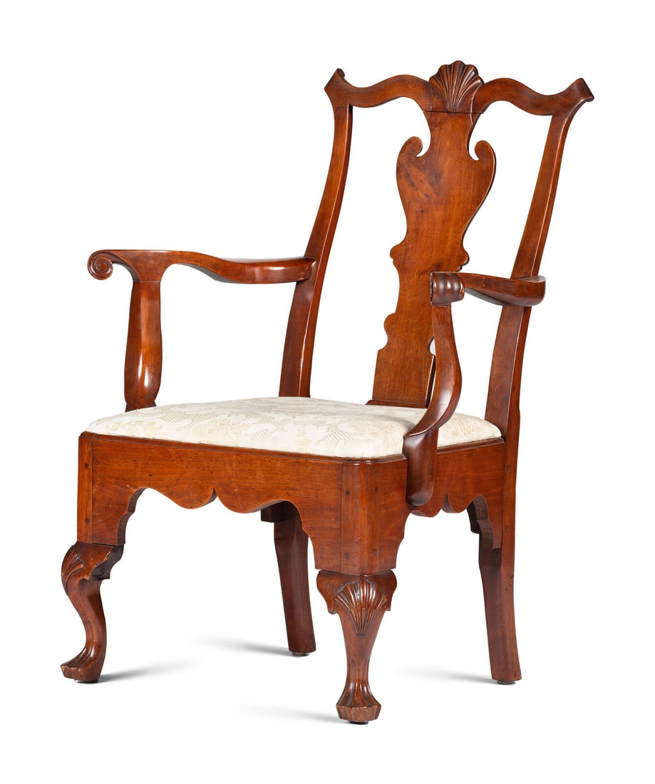 A Queen Anne Carved Walnut Armchair: A Queen Anne Carved Walnut Armchair Philadelphia, Pennsylvania, Circa 1770 the shaped crest centered by carved shell, over solid shaped splat, scrolled arms, on frame with shaped apron, the seat rail