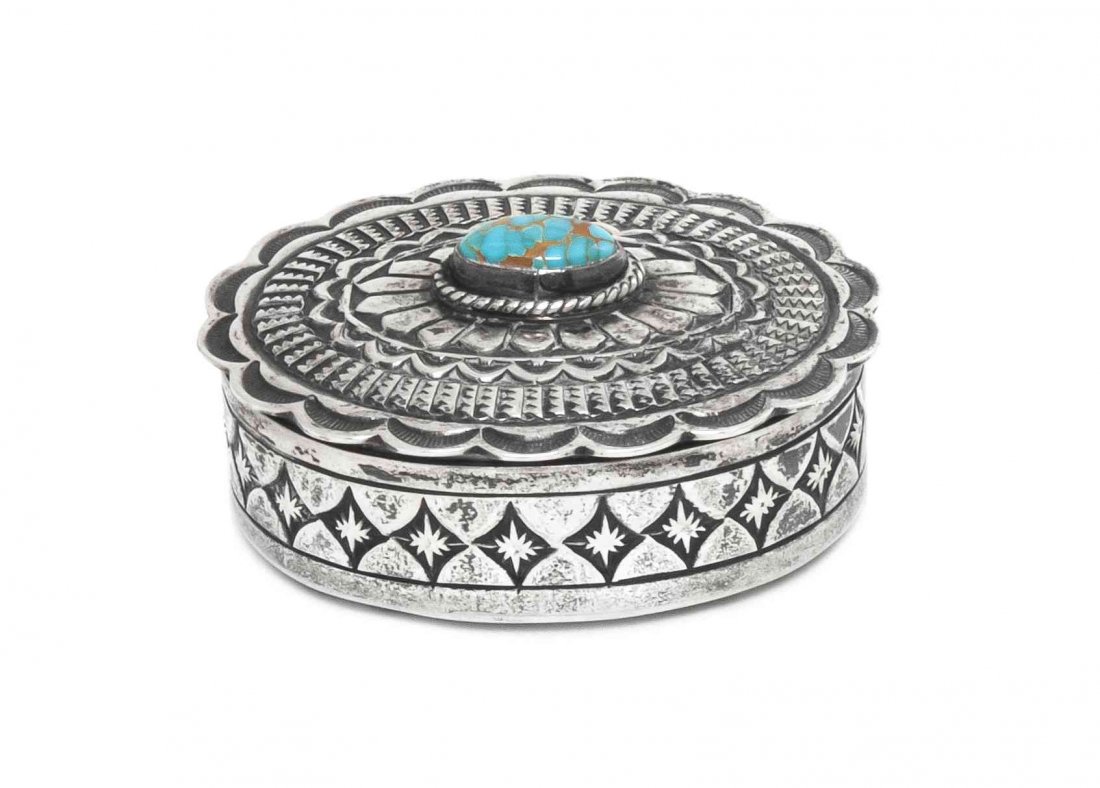 A Navajo Oval Sterling Silver and Turquoise Lidded Stam: A Navajo Oval Sterling Silver and Turquoise Lidded Stampwork Box, Gary Reeves, lid mounted with oval cabochon turquoise stone at center, marked Gary Reeves, Sterling. Height 1 x width 1 3/4 x depth 2 