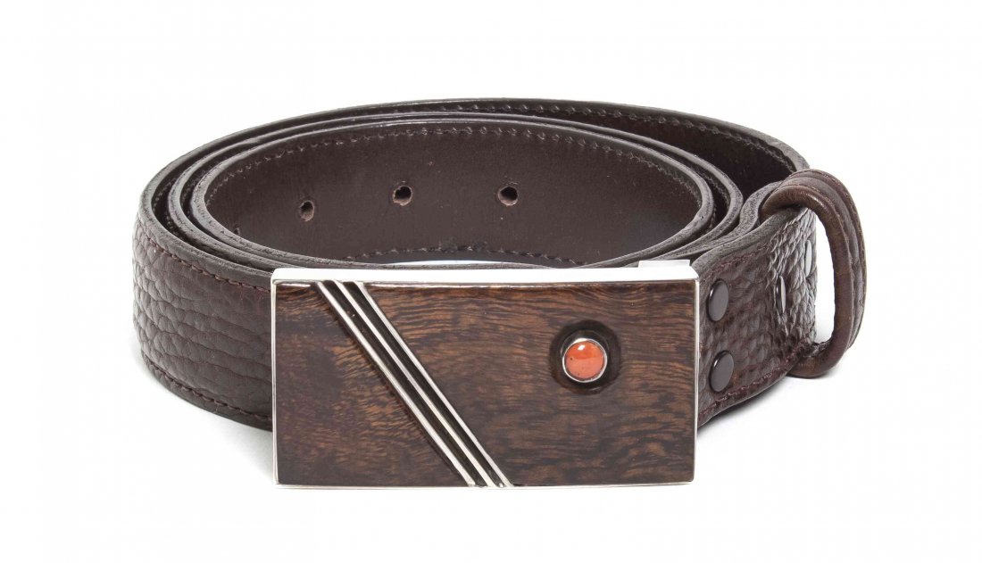 A Navajo Sterling Silver and Coral Belt Buckle, Edison: A Navajo Sterling Silver and Coral Belt Buckle, Edison Cummings, having rectangular form set with diagonal silver bars bisecting ironwood bars set with coral cabochon in a recessed reserve, marked E. 
