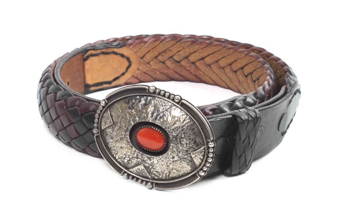 A Kiowa Sterling Silver and Coral Belt Buckle, Byron Mc: A Kiowa Sterling Silver and Coral Belt Buckle, Byron McCurtain, having oval shape with center coral cabochon in deeply recessed reserve, surrounded by a textured shadow box with alternating raindrop a