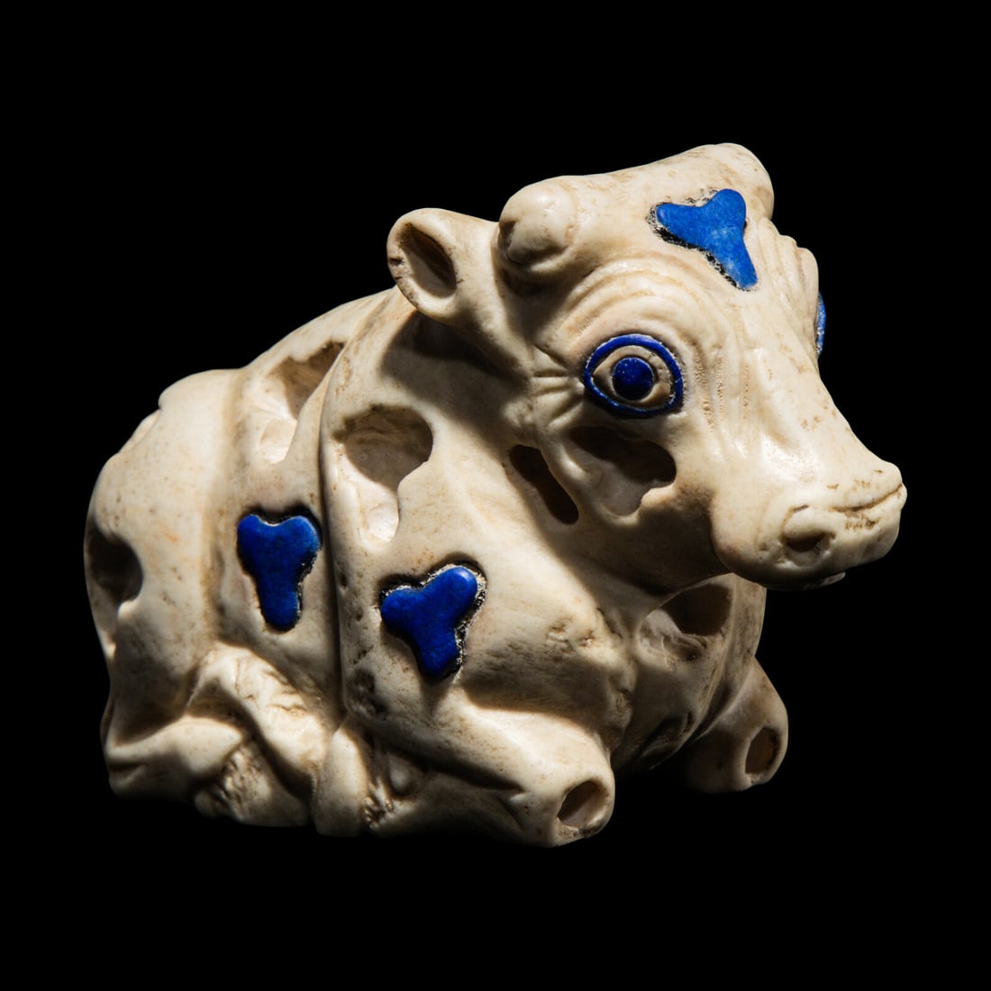 A Mesopotamian Marble and Lapis Lazuli Inlay Recumbent Calf: A Mesopotamian Marble and Lapis Lazuli Inlay Recumbent Calf Late Uruk-Jemdat Nasr Period, Circa 3300-2900 B.C. Length 7 cm (2 3/4 inches). Provenance: Private Collection, United Kingdom, 1979. Ariadne