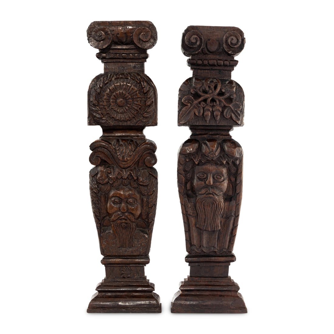 Two James I Carved Oak Balusters: Two James I Carved Oak Balusters First Quarter 17th Century each carved with a figural decoration beneath a foliate or floral motif and ionic capital. Height 20 inches. Property from the Collection of