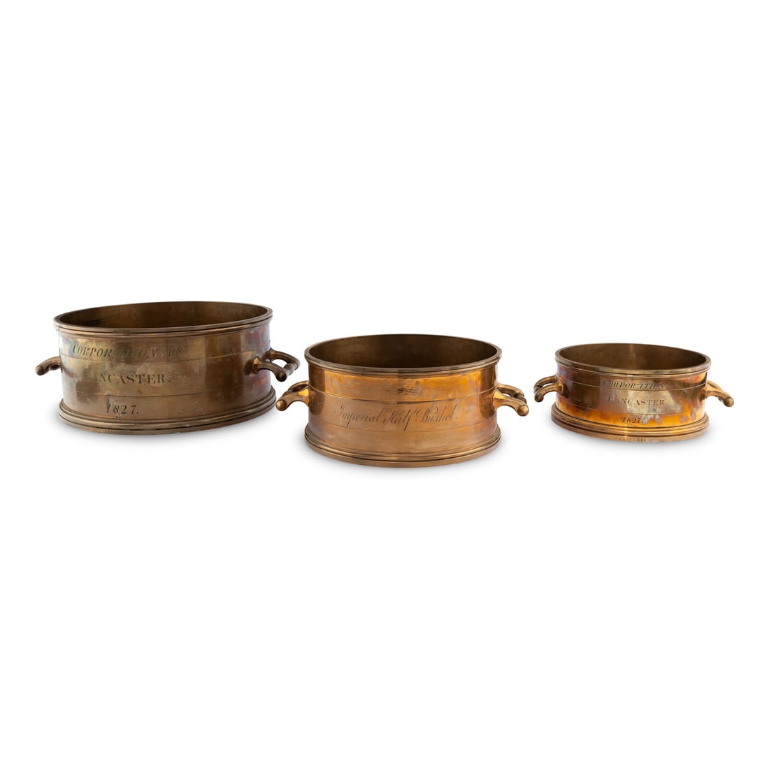 An Assembled Set of Nine English Brass Imperial Standard Grain Measures: An Assembled Set of Nine English Brass Imperial Standard Grain Measures 19th Century comprising: bushel, half-bushel and peck each engraved Corporation of Lancaster, 1827, together with an associated