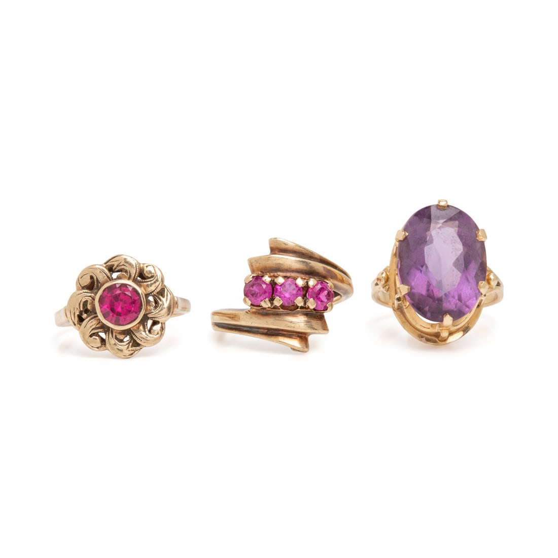 Three Multigem Rings: Three Multigem Rings Including one ring with an oval amethyst weighing approximately 6.65 carats by formula, one with a round pink synthetic sapphire, and one with three round synthetic pink