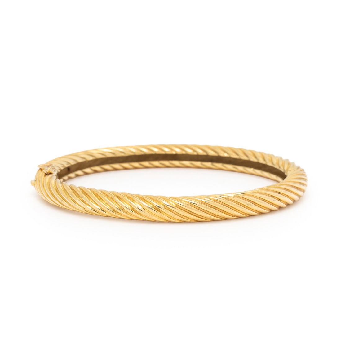 Yellow Gold Twisted Bangle Bracelet: Yellow Gold Twisted Bangle Bracelet Hinged with a side clasp. 18 karat yellow gold. 6 1/4 inches inner circumference. Stamp: (maker's mark) 18K. Gross weight: 22.95 dwt. This lot is located in Chicago