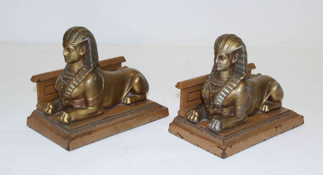 A Pair of Art Deco Style Parcel Gilt and Painted Metal: A Pair of Art Deco Style Parcel Gilt and Painted Metal Bookends, each in the form of a sphinx. Width 8 1/4 inches. Property from the Collection of John Robert Wiltgen, Chicago, Illinois