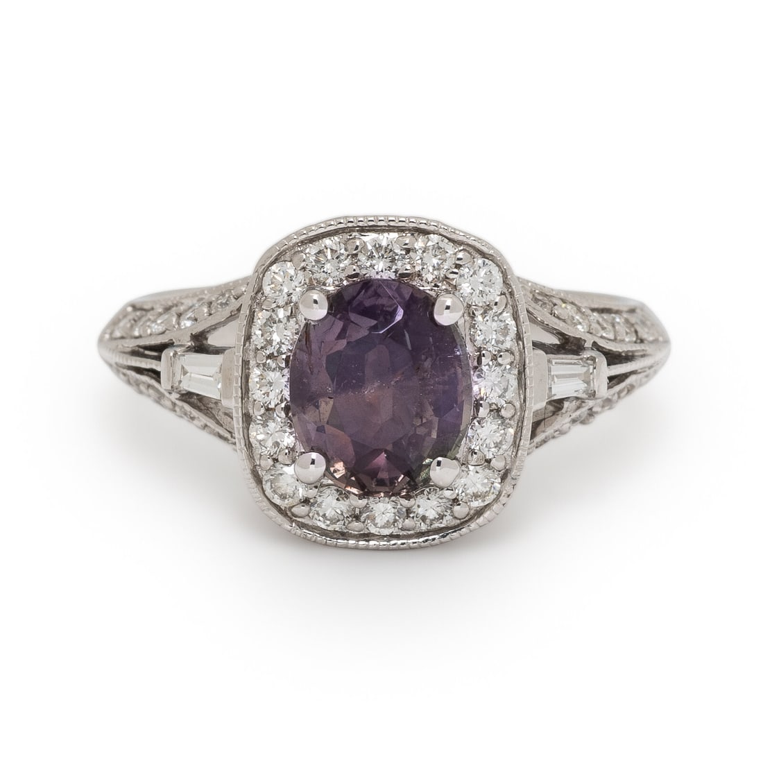 Alexandrite and Diamond Ring: Alexandrite and Diamond Ring Featuring an oval Alexandrite weighing 1.59 carats, surrounded by tapered baguette and round brilliant cut diamonds weighing approximately 1.05 carats total. Mounted in 14