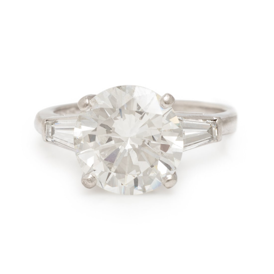Diamond and Platinum Ring: Diamond and Platinum Ring Featuring a round brilliant cut diamond weighing 3.30 carats, flanked by tapered baguette cut diamonds weighing approximately 0.40 carat total. Mounted in platinum. Ring size