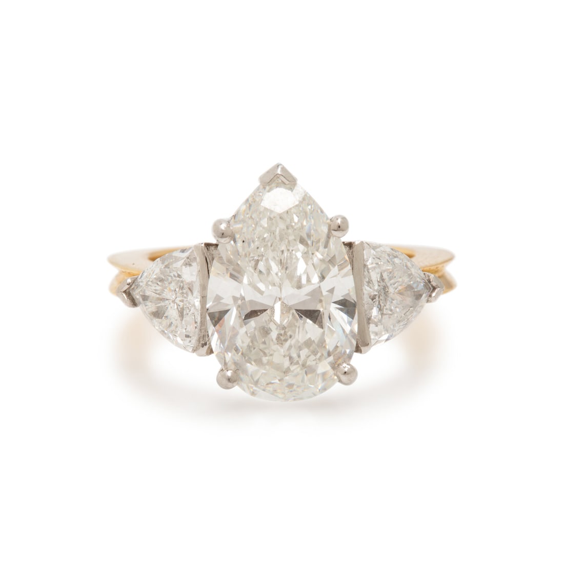 Diamond, Platinum, and Yellow Gold Ring: Diamond, Platinum, and Yellow Gold Ring Featuring a pear shape diamond weighing 5.08 carats, flanked by trillion cut diamonds weighing approximately 1.55 carats total. Mounted in 18 karat yellow gold 
