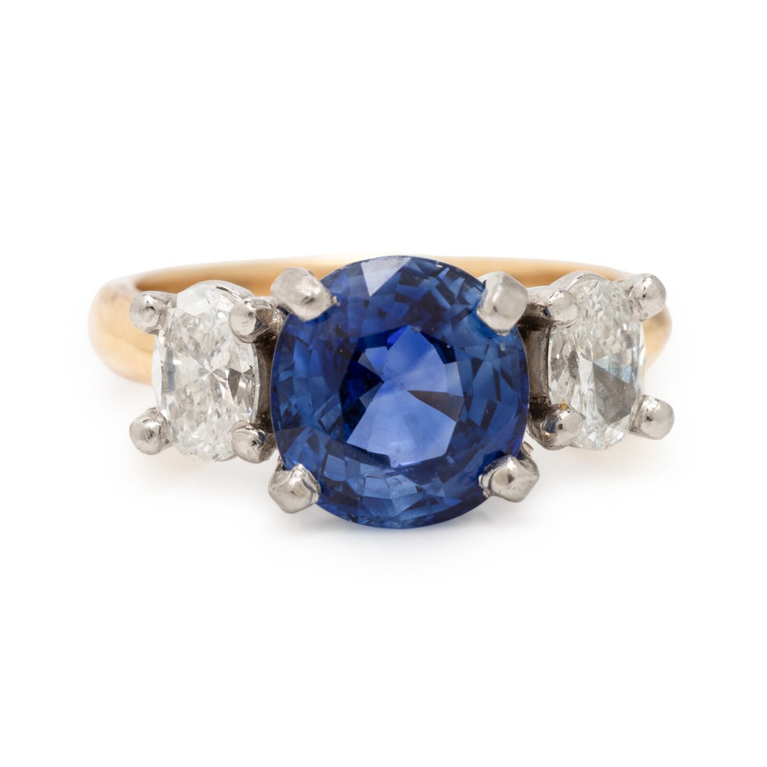 Ceylon Sapphire and Diamond Ring: Ceylon Sapphire and Diamond Ring Featuring a round sapphire weighing approximately 3.60 carats by formula, flanked by oval diamonds weighing approximately 1.10 carats total. Mounted in 18 karat yellow