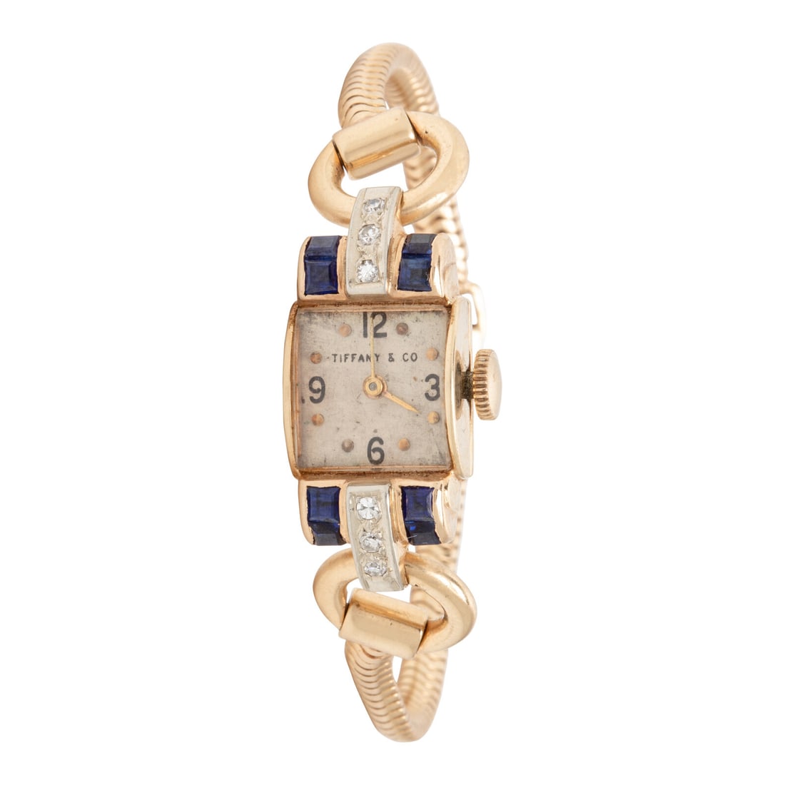 Tiffany & Co, Retro, Yellow Gold, Sapphire, and Diamond Watch: Tiffany & Co, Retro, Yellow Gold, Sapphire, and Diamond Watch Model: Tiffany & Co. Year: Circa 1940s Case size: Approx. 12 mm Case material: Yellow gold Bezel: Calibré cut sapphires and round bri