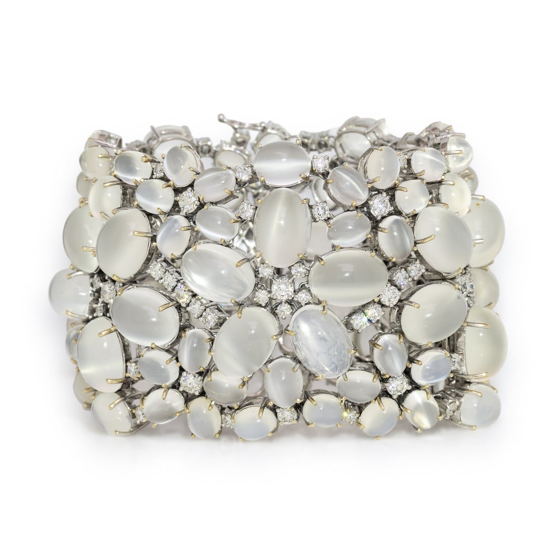 Moonstone, Diamond, and White Gold Bracelet: Moonstone, Diamond, and White Gold Bracelet In an openwork design with floral motifs, set throughout with oval cabochon cat's eye moonstones measuring approximately 7.45 x 5.80 x 3.40 - 14.10 x 10.00 
