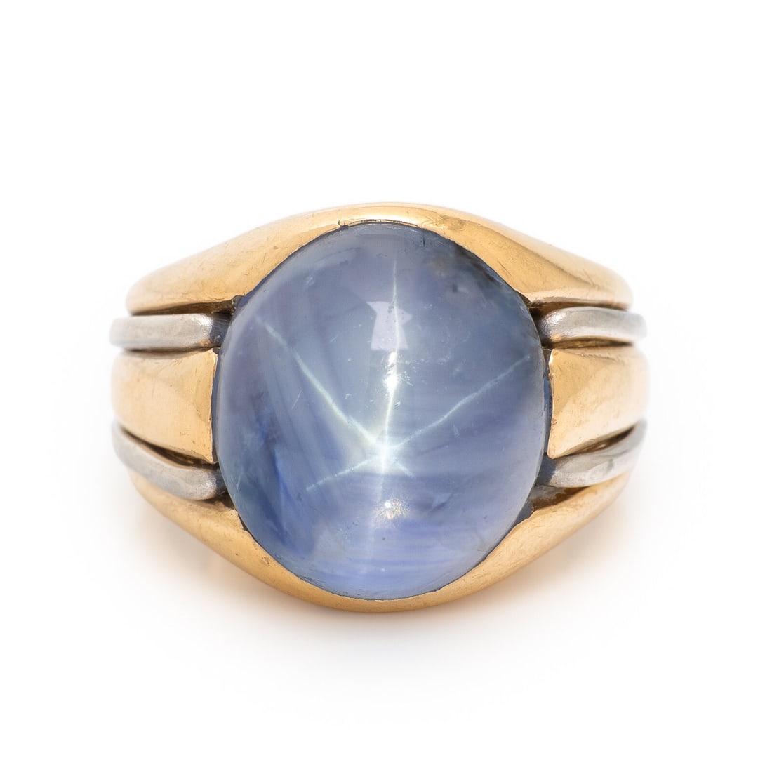 Star Sapphire and Bicolor Gold Ring: Star Sapphire and Bicolor Gold Ring Featuring a star sapphire weighing approximately 26.25 carats by formula. Mounted in yellow and white gold. Ring size 5 1/4. Gross weight: 17.95 dwt. Property from 