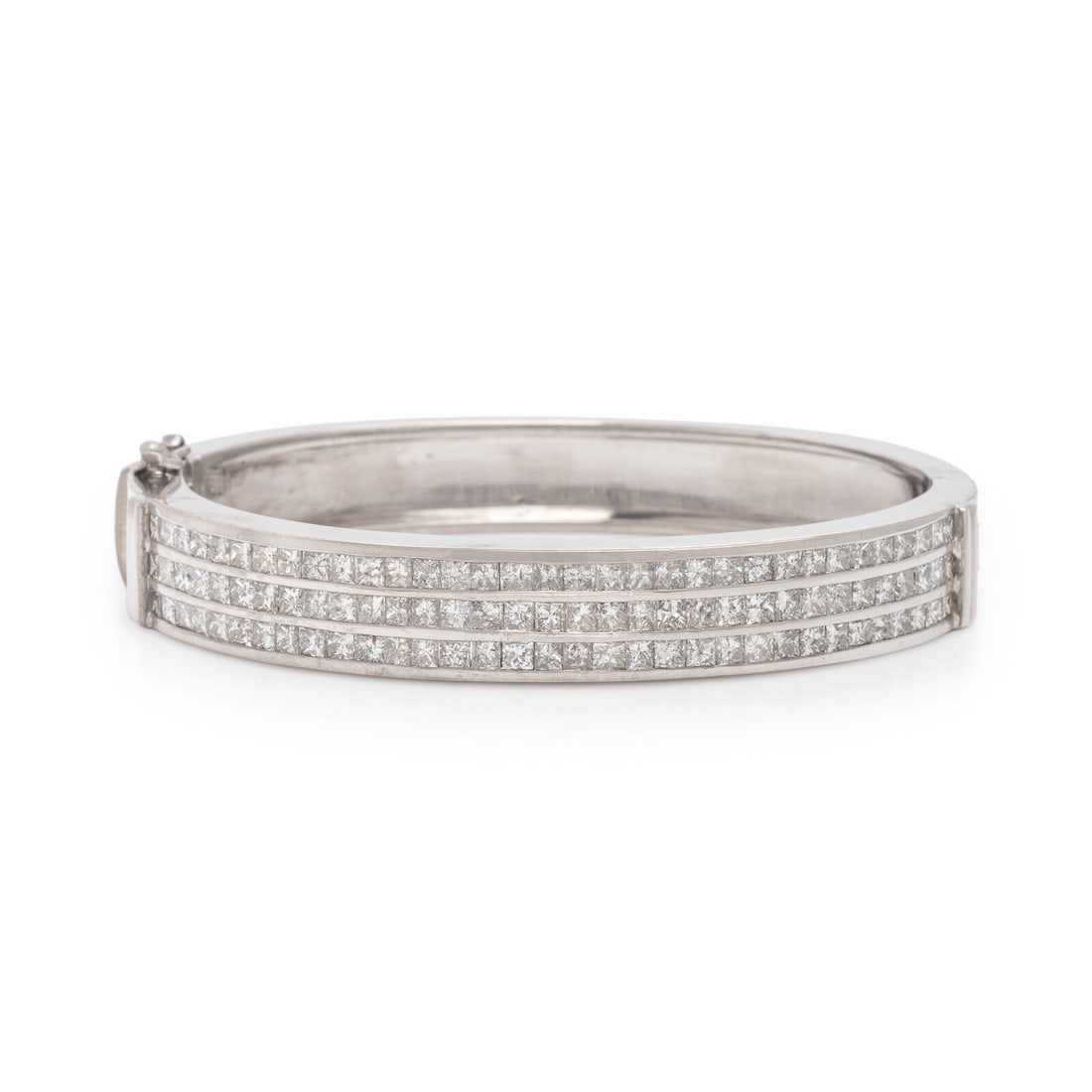Diamond and White Gold Bangle Bracelet: Diamond and White Gold Bangle Bracelet Channel-set with three rows of princess cut diamonds weighing approximately 6.35 carats total, hinged with side clasp. Mounted in 18 karat white gold. 6 1/2 inch
