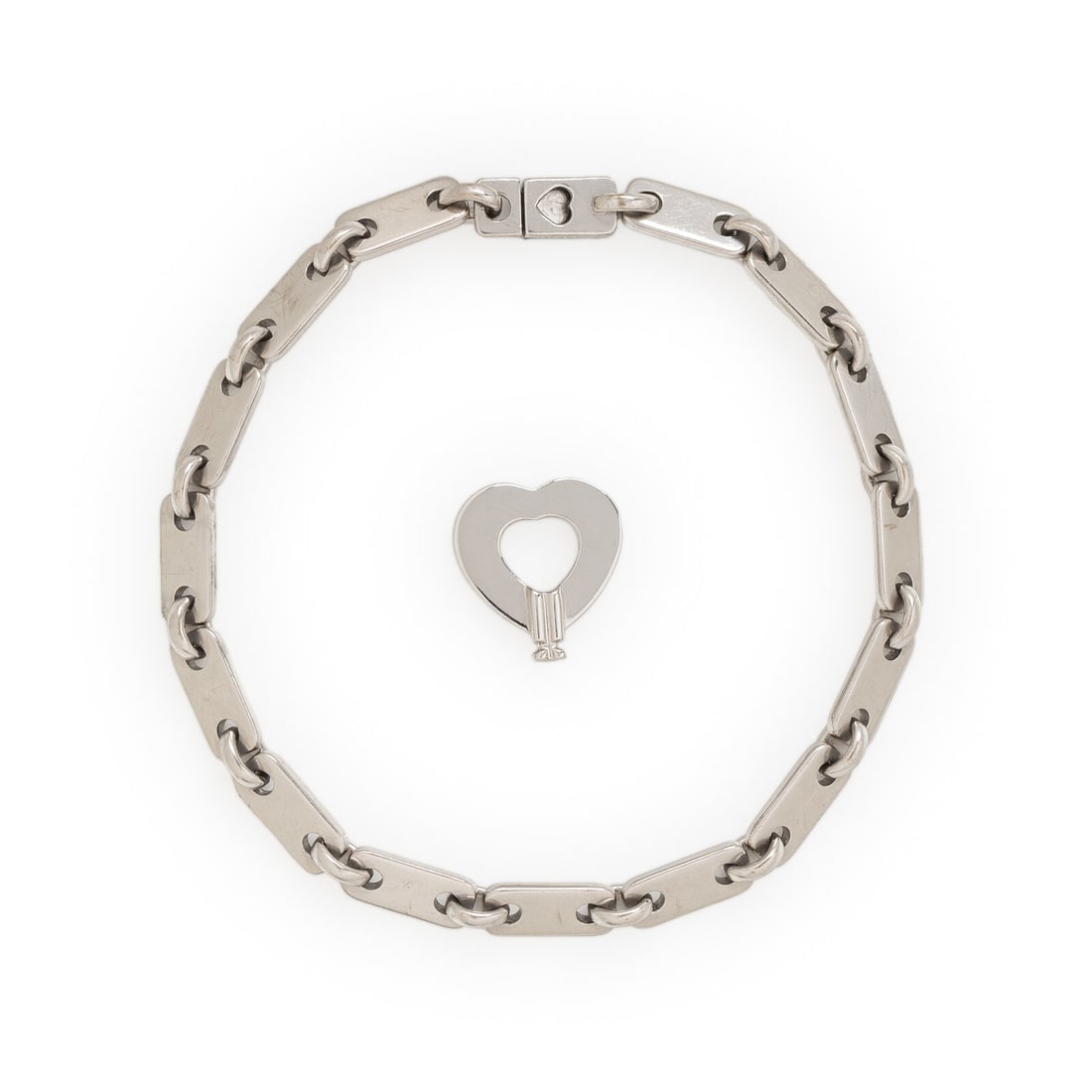 Cartier, White Gold 'Fidelity' Bracelet and Key: Cartier, White Gold 'Fidelity' Bracelet and Key Designed with rectangular links, with a push clasp that is opened with the heart shape key pendant. 18 karat white gold. 7 1/8 inches long. Bracelet sta