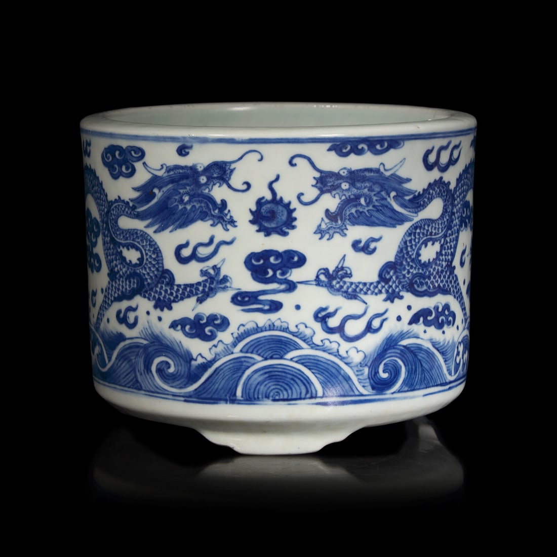 A Chinese Blue and White "Dragons" Tripod Porcelain Censer, Qing Dynasty: A Chinese Blue and White "Dragons" Tripod Porcelain Censer, Qing Dynasty 清 青花云龍紋三足爐 Decorated with a pair of dragon raising from crashing