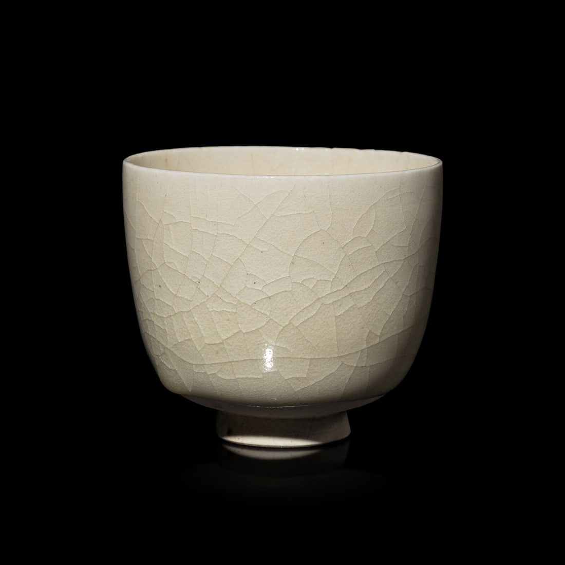 A Chinese White Glazed Cup: A Chinese White Glazed Cup 白釉杯 With deep, rounded sides resting on a short, splayed foot, covered with a finely crackled, transparent, glossy glaze, the flat base left unglazed, r