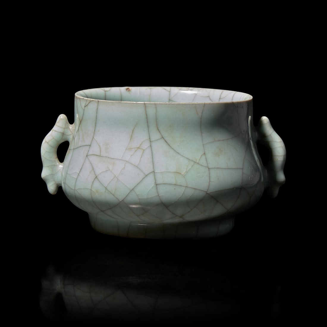 A Chinese Guan-Style Censer: A Chinese Guan-Style Censer 仿官窯雙魚耳爐 Of bombe form, with twin handles, the soft green glaze with a network of gray craquelure, unmarked Diameter 6 1/8 i