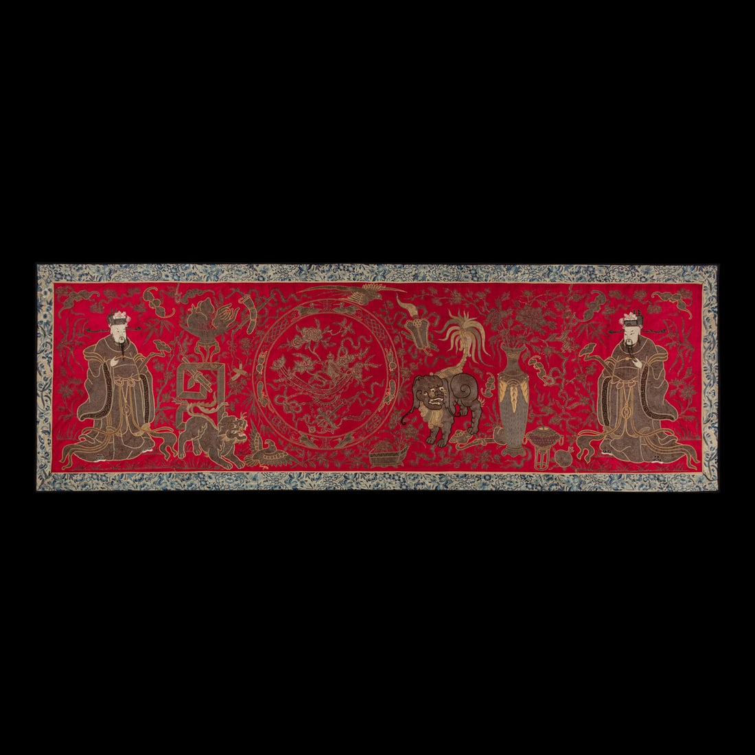 A Chinese Red Ground Embroidered Silk 'Immortals' Panel, Late 19th-Early 20th Century: A Chinese Red Ground Embroidered Silk 'Immortals' Panel, Late 19th-Early 20th Century 清晚期 紅地綉八仙圖 Depicting two immortals, lions and antiq