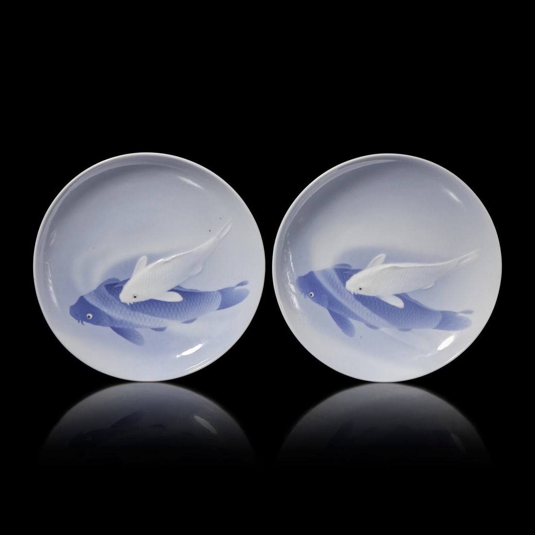 A Pair of Japanese Blue and White "Koi" Dishes, Signed, Meiji/Taisho Period: A Pair of Japanese Blue and White "Koi" Dishes, Signed, Meiji/Taisho Period Possibly by Shofu Katei (Kajo) (1870-1928). The interior depicting a painted underglaze blue fish and a raised white slip fi