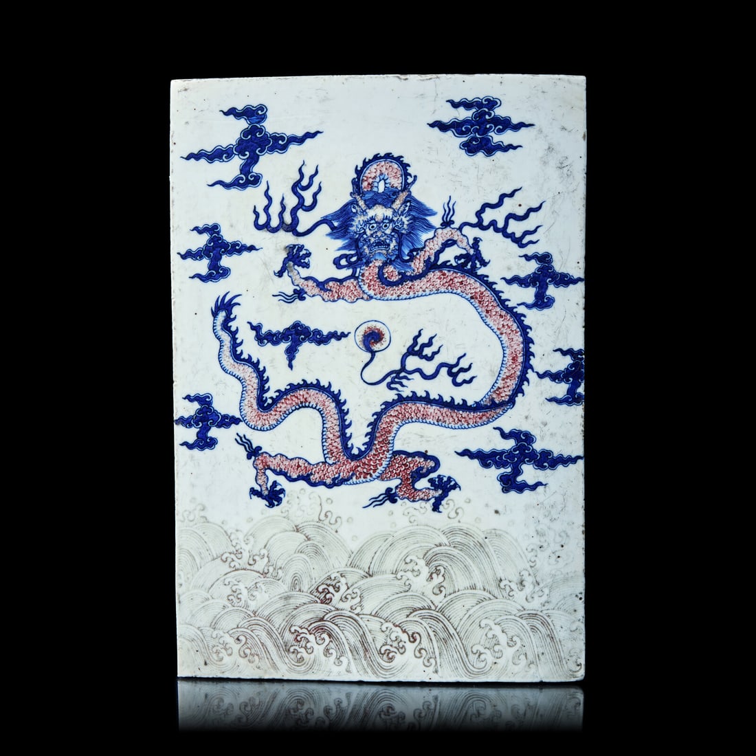 A Chinese Underglazed Red and Blue Porcelain 'Dragon' Plaque ???????????: A Chinese Underglazed Red and Blue Porcelain 'Dragon' Plaque ??????????? Painted to the front showing a writhing dragon encircling the pearl of wisdom amongst clouds and above crashing waves. Height 1