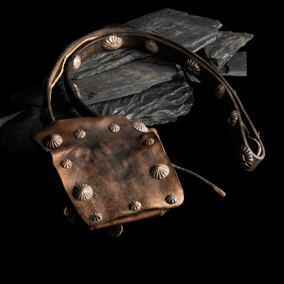 Navajo Bandolier Bag: Navajo Bandolier Bag first half 20th century leather bag decorated with seventeen conchas on the strap and eleven conchas on the bag overall length 26-1/2 inches x width 6 inches This lot is located i