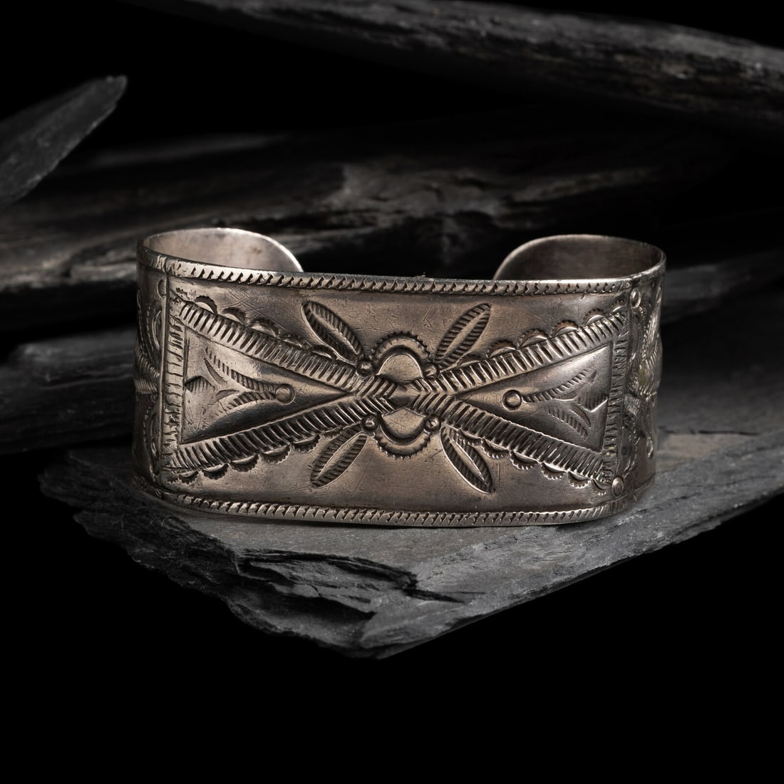 Early Navajo Heavily Stamped and Chiseled Ingot Cuff Bracelet, with RepoussÈ Elements: Early Navajo Heavily Stamped and Chiseled Ingot Cuff Bracelet, with RepoussÈ Elements ca 1885 stacked repoussÈ triangular elements accented with stamp work; not marked width 1-1/8 inches int