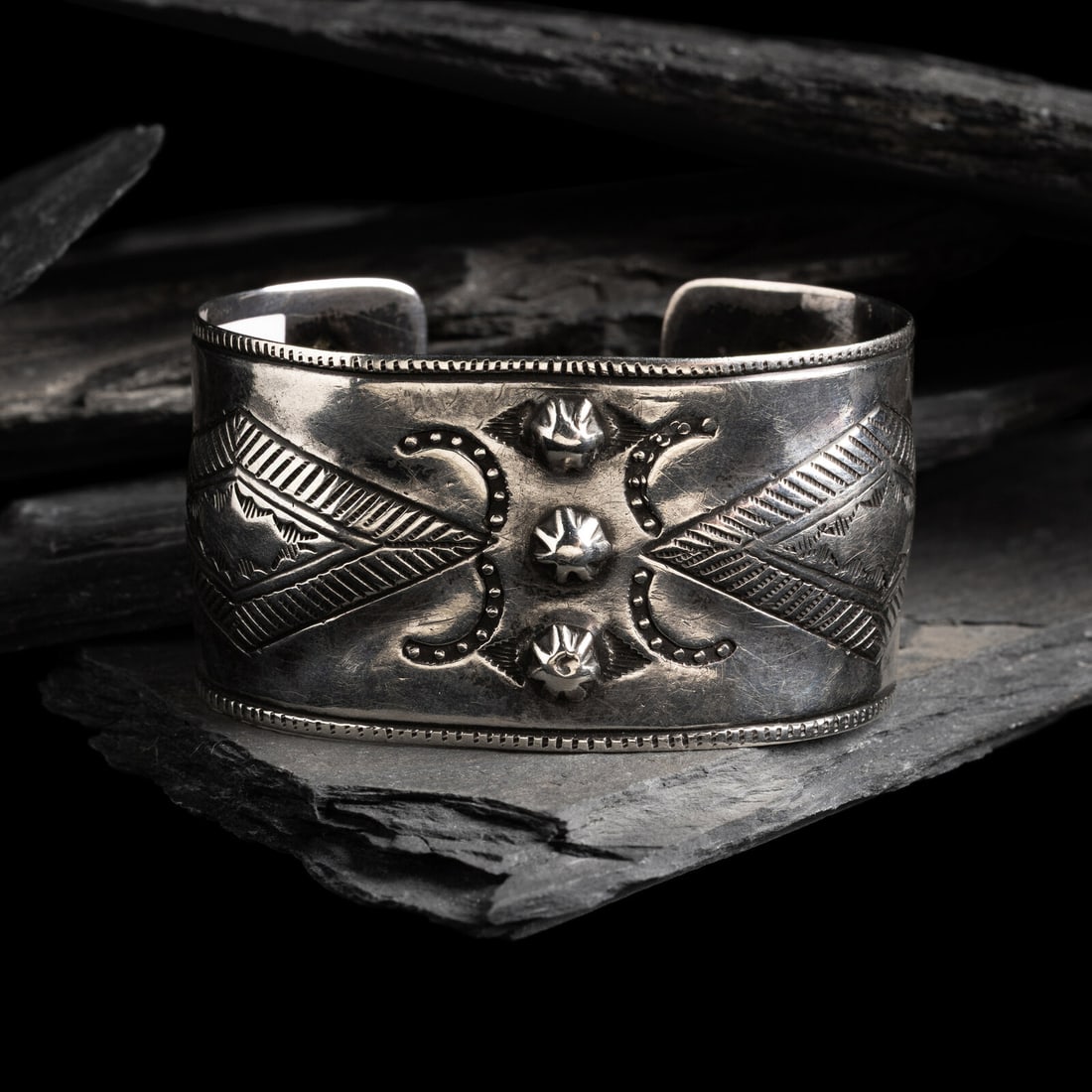 Early Navajo Stamped Ingot Cuff Bracelet: Early Navajo Stamped Ingot Cuff Bracelet ca 1890 featuring offset chiseled repoussÈd diamonds with three central fluted bump outs accented with crescent horseshoe shapes; not marked width 1-5/16 
