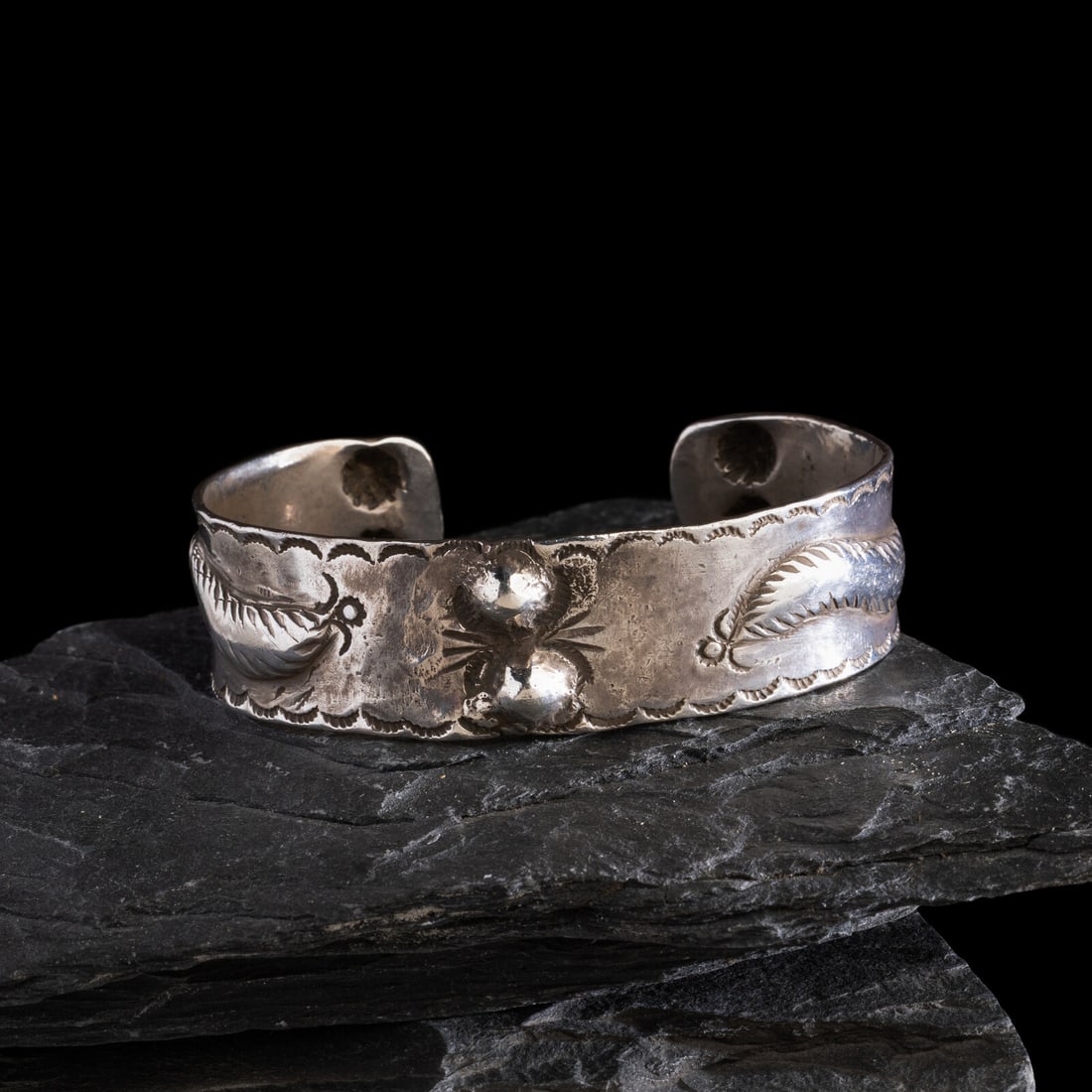 Early Navajo Ingot Cuff Bracelet: Early Navajo Ingot Cuff Bracelet ca 1890-1900 six repoussÈ beads and two repoussÈd winged elements, each accented with stamping along the edge and chisel work; not marked width 3/4 inch inte
