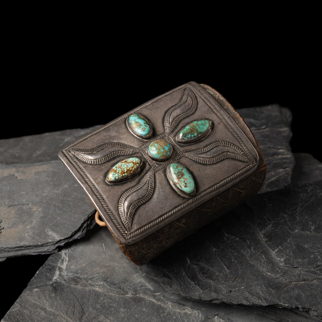Early Navajo Ingot and Turquoise Ketoh, with Carved Design on Leather Band: Early Navajo Ingot and Turquoise Ketoh, with Carved Design on Leather Band ca 1890-1910 chiseled border and repoussÈ elements accented by four stones; the leather band features carved designs on