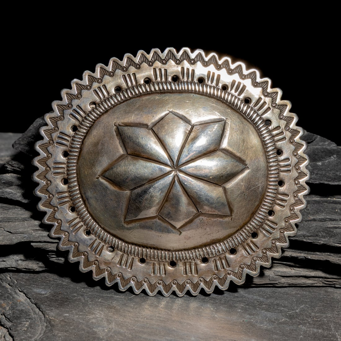 Repurposed Belt Buckle from Early Navajo Second Phase Concha: Repurposed Belt Buckle from Early Navajo Second Phase Concha ca 1890-1900 stamped serrated edge, featuring a a central repoussÈ eight point star design; not marked height 3-3/4 inches x width