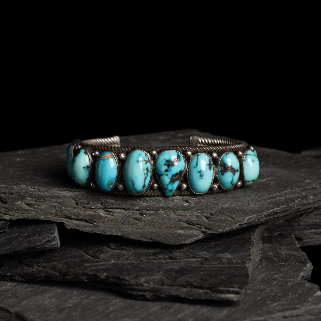 Navajo Twisted Wire and Turquoise Cuff Bracelet: Navajo Twisted Wire and Turquoise Cuff Bracelet ca 1920s-1930s set with a row on nine stones in various shapes; not marked width 7/8 inch interior circumference 6 inches + gap length 1-3/16 inch weigh