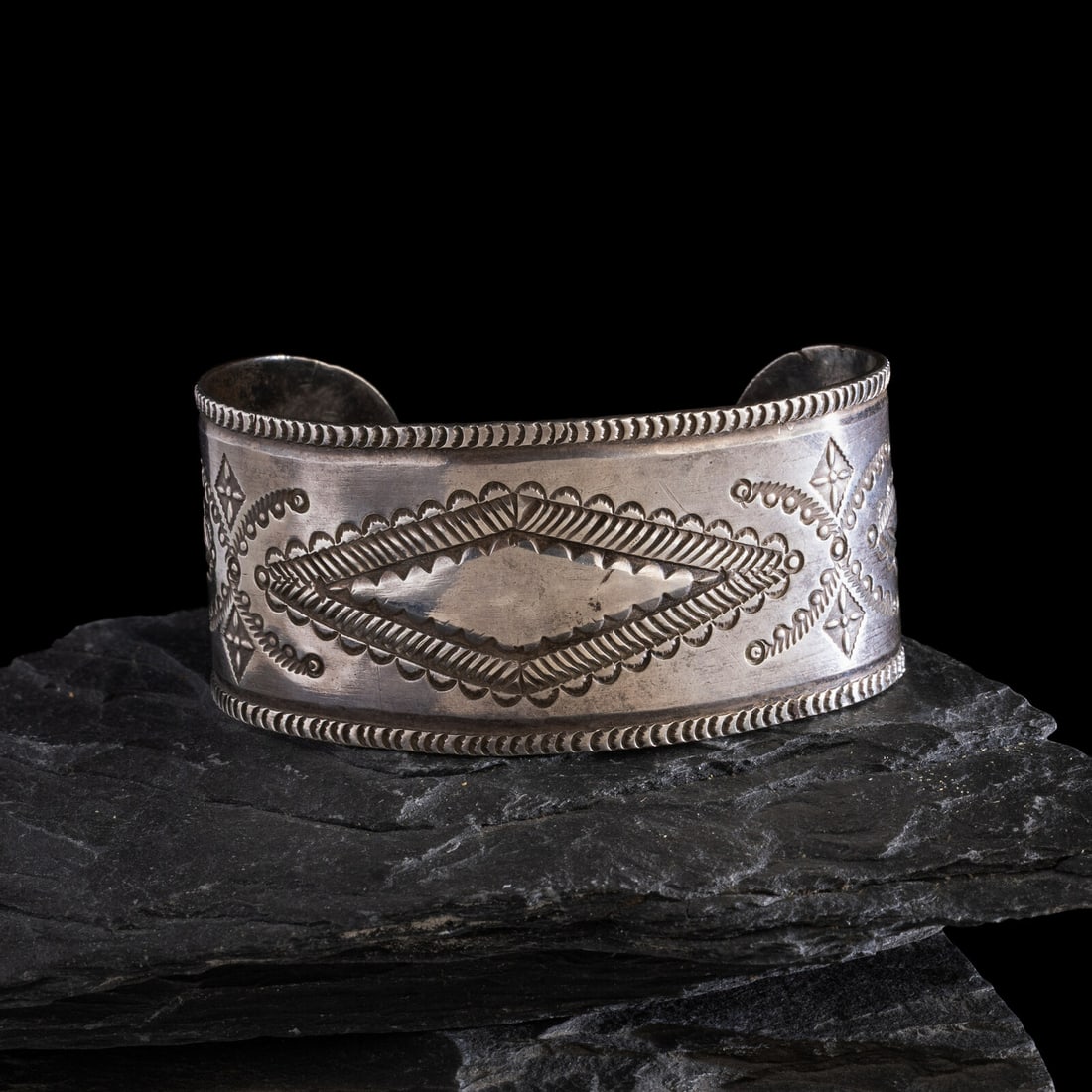Navajo Stamped Ingot Cuff Bracelet: Navajo Stamped Ingot Cuff Bracelet ca 1900-1910 elegantly stamped and chiseled design with central diamond and waterbugs; mot marked width 1-1/4 inches interior circumference 5-1/2 inches + gap length