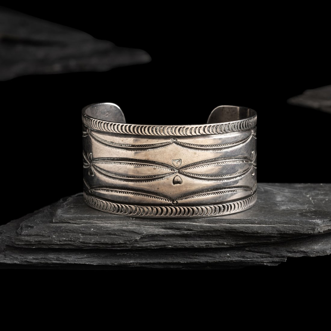 Navajo Ingot Cuff Bracelet, with Heart Stamps: Navajo Ingot Cuff Bracelet, with Heart Stamps early 20th century parallel curvilinear stamps accented by hearts; not marked cuff width 1-1/4 inches interior circumference 5-1/2 inches + gap length 1-1