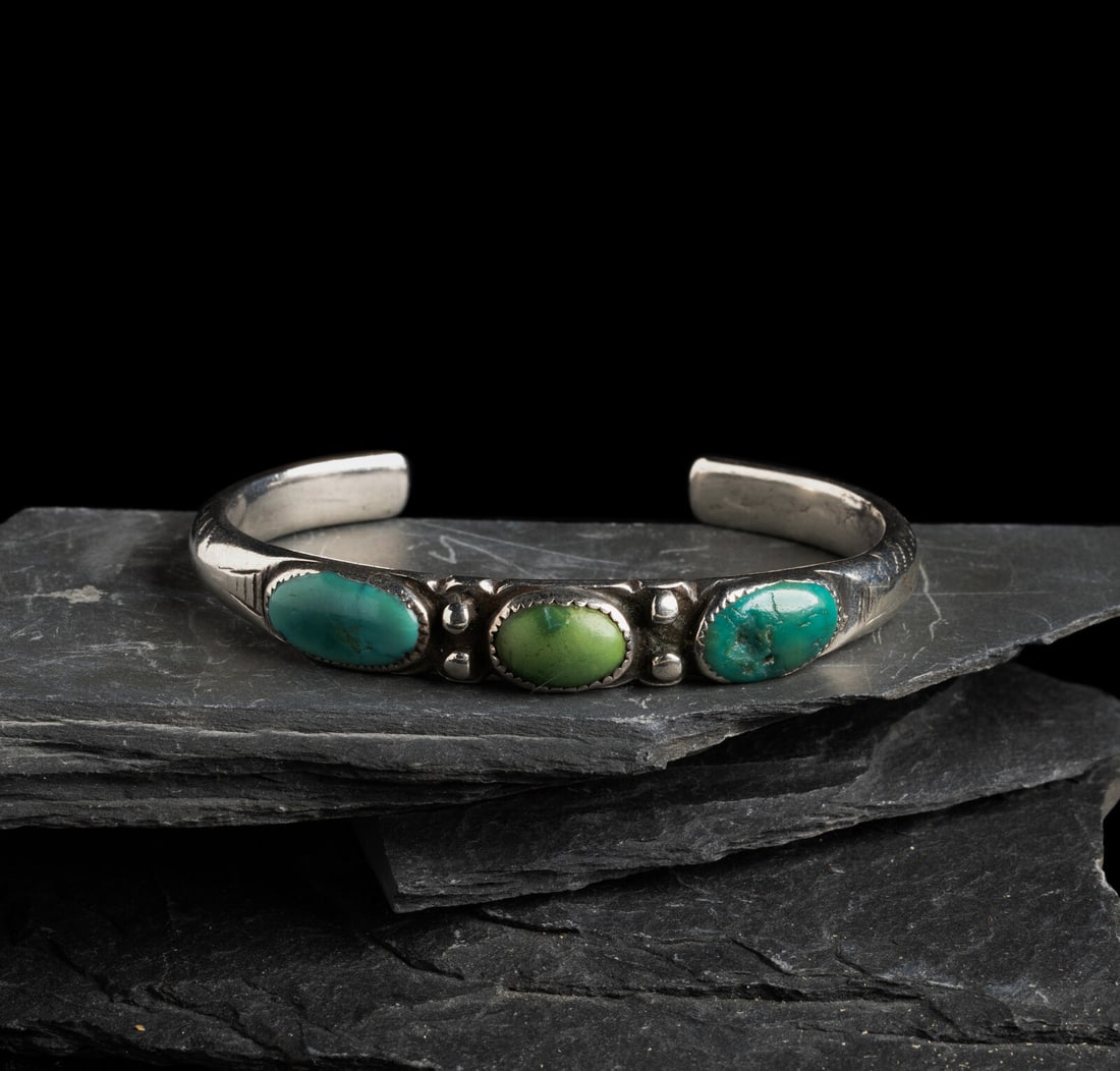 Navajo Chiseled Ingot and Turquoise Cuff Bracelet: Navajo Chiseled Ingot and Turquoise Cuff Bracelet ca 1900-1910 heavily worn chiseled designs on shank and set with three stones in heavily worn serrated bezels; not marked width 3/8 inch interior circ