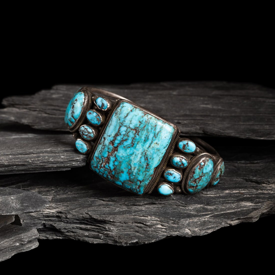 Navajo Turquoise Cluster Cuff Bracelet: Navajo Turquoise Cluster Cuff Bracelet ca 1920s - 1930s wire cuff set with thirteen stones; not marked width 1-1/2 inches interior circumference 6-1/8 inches + gap length 1 inch weight 53.2 dwt. This 