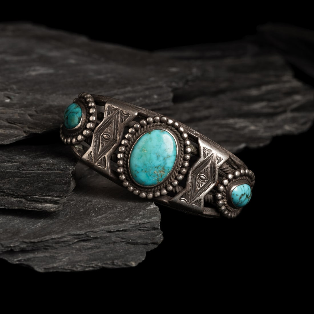 Navajo Silver and Turquoise Cuff Bracelet: Navajo Silver and Turquoise Cuff Bracelet ca 1930s stamped carinated bands alternate with twisted wires to form the cuff; set with three stones alternating with stamped silver appliquÈ; not marke