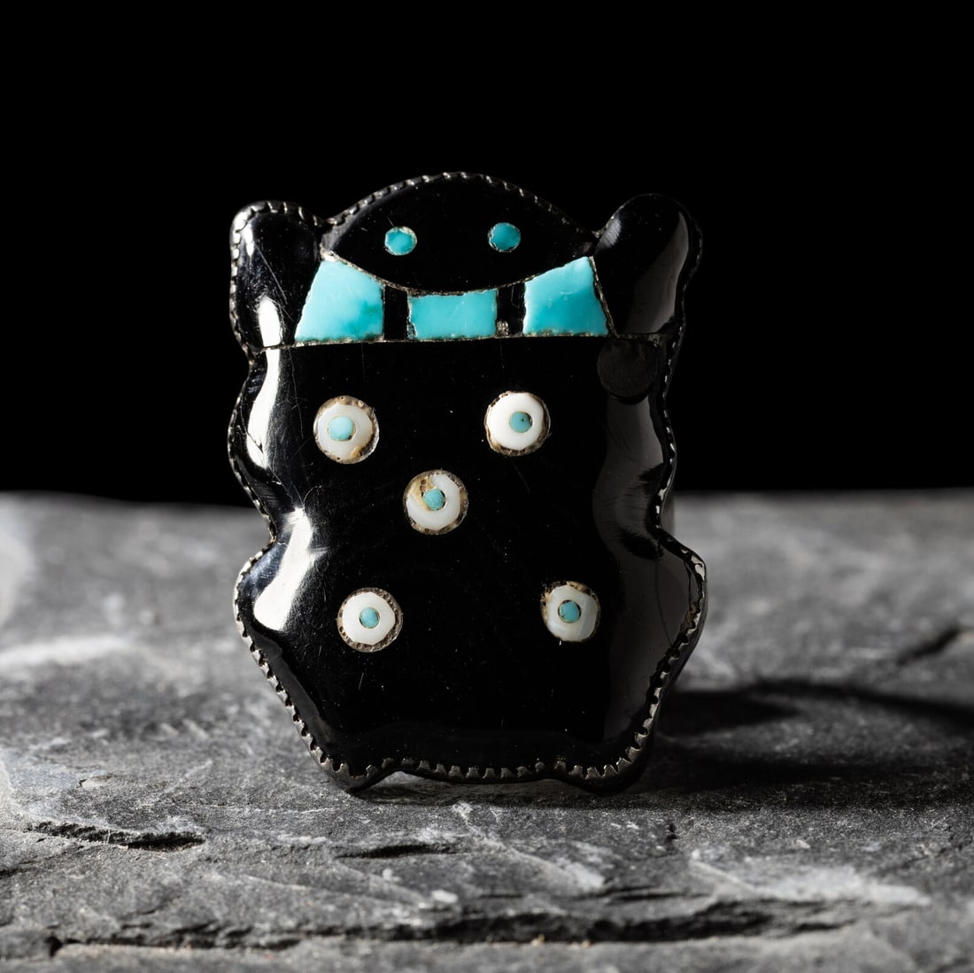Zuni Multi-stone Inlay Frog Ring: Zuni Multi-stone Inlay Frog Ring mid-20th century set with jet, turquoise, and shell; etched with a trader/pawn code TIH size 6 face length 1-1/8 inches x width 1 inch weight 4.7 dwt. The Collection