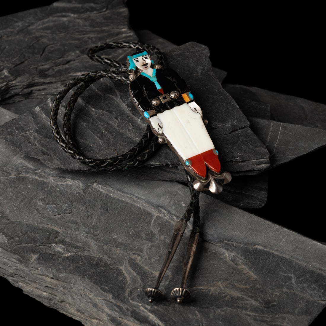 Zuni Figural Mosaic Inlay Bolo Tie: Zuni Figural Mosaic Inlay Bolo Tie mid-20th century not marked slide length 4-3/4 inches x width 1-3/8 inches bolo length 25 inches total weight 31.8 dwt. This lot is located in Chicago.