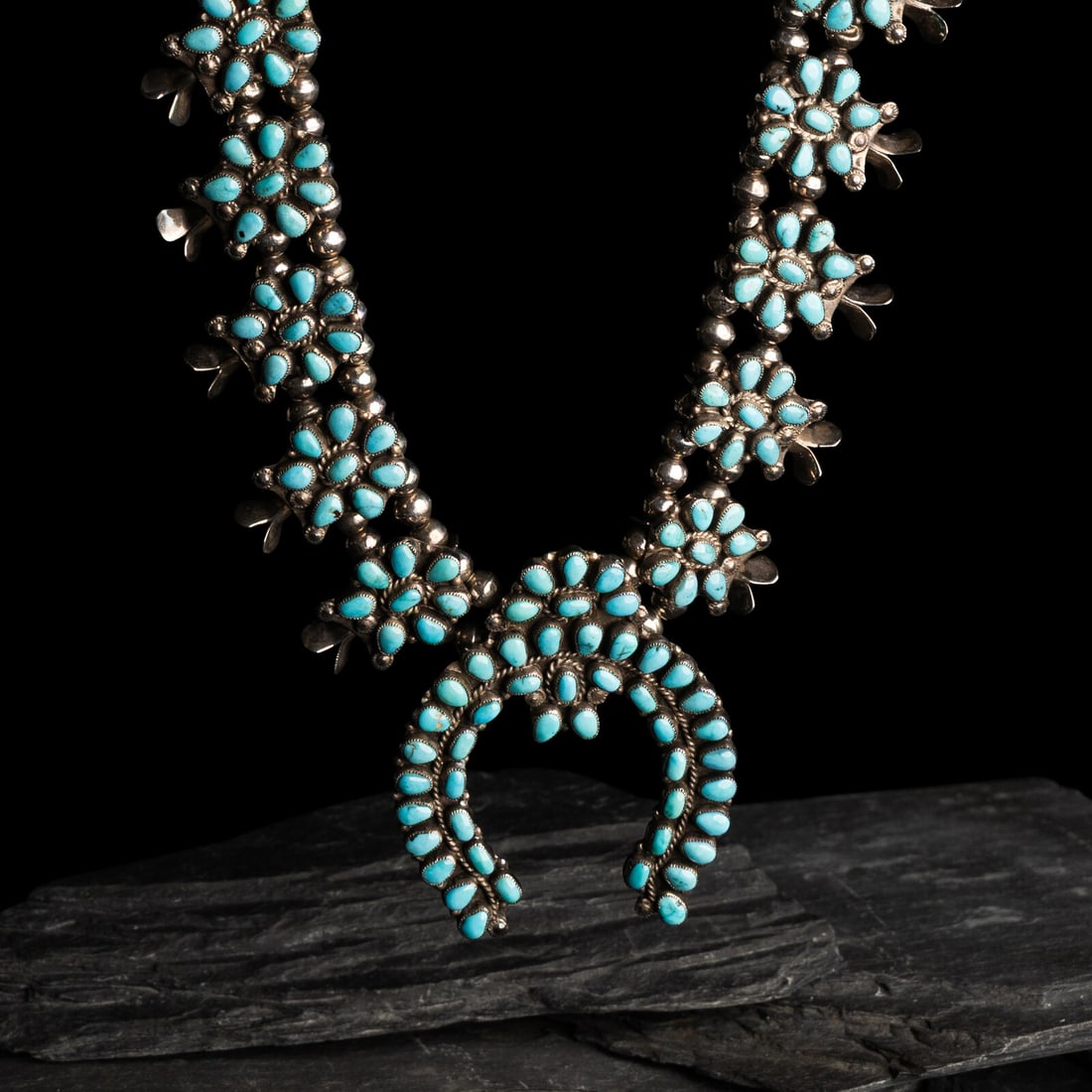 Zuni Silver and Turquoise Cluster Squash Blossom Necklace: Zuni Silver and Turquoise Cluster Squash Blossom Necklace mid-20th century twelve squash blossoms center around the naja; not marked length 23-1/2 inches naja length 2-5/8 inches x width 2 inches