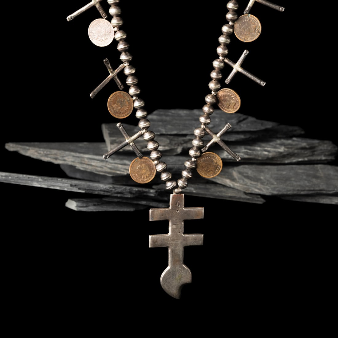 Isletsa Cross Necklace: Isletsa Cross Necklace mid-20th century single-strand necklace strung with six crosses alternating with Indian head pennies and featuring a central double cross pendant length 23-3/4 inches pendant