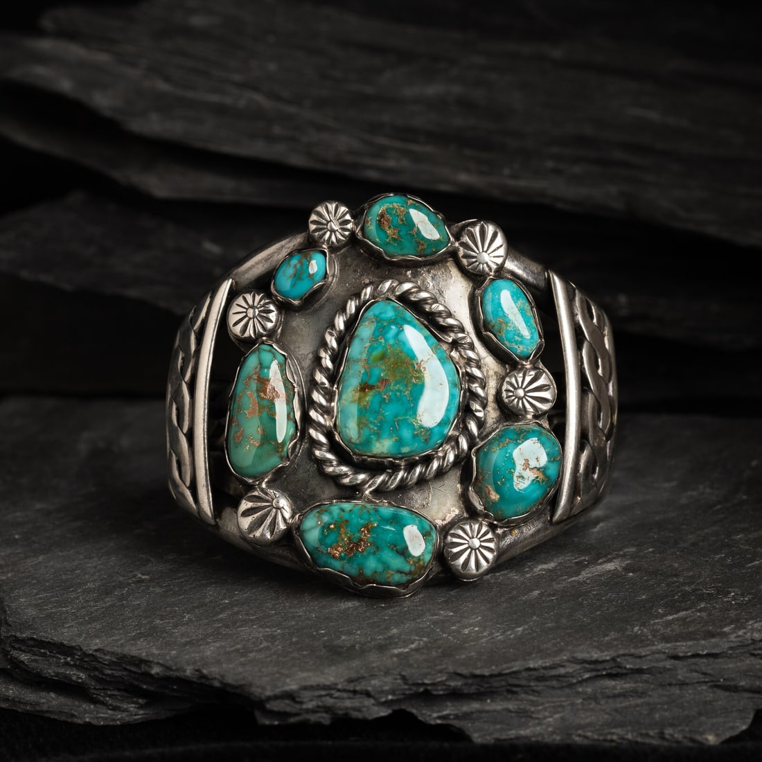 Navajo Silver and Royston Turquoise Cluster Cuff Bracelet: Navajo Silver and Royston Turquoise Cluster Cuff Bracelet mid-20th century set with seven stones in varying sizes; not marked width 2-1/4 inches interior circumference 5-1/2 inches + gap length 7/8 in