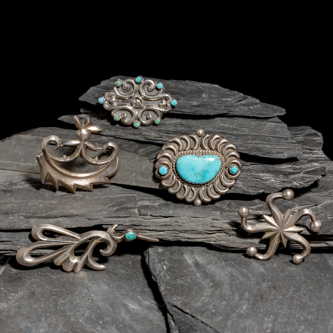 Navajo Sandcast Pins / Brooches: Navajo Sandcast Pins / Brooches mid-20th century lot of 5, includes one set with three turquoise stones; not marked length 2 inches x width 2-1/8 inches weight 12.5 dwt. one set with eight petit